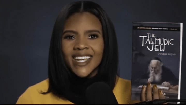 A woman holds a book titled The Talmudic Jew.