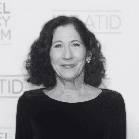 Black and white photo of a woman smiling at the camera.