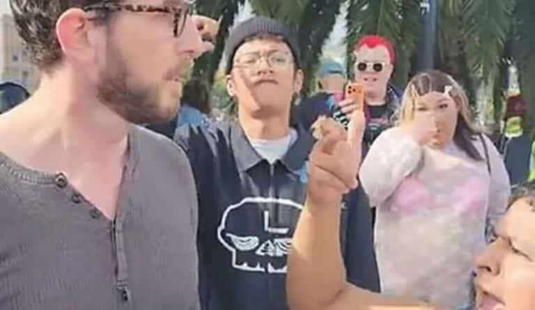 A man with glasses is arguing with a woman in a crowd.